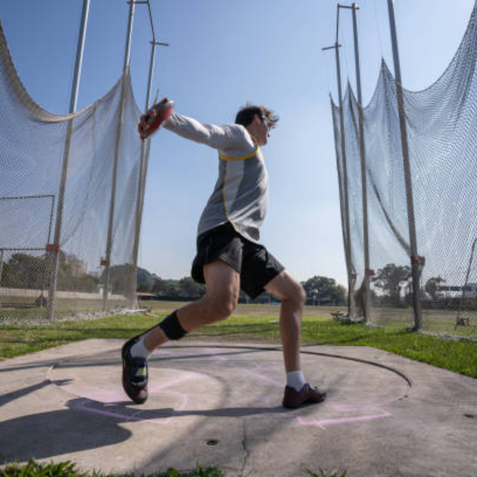 Track and field throwing implements, including a discus, hammer, javelin, and shot put, arranged to represent the four major throwing events.