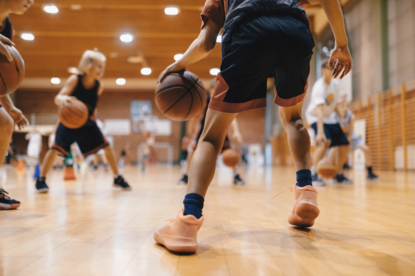 Young athletes participating in basketball drills and teamwork exercises at 12th Rock Sports